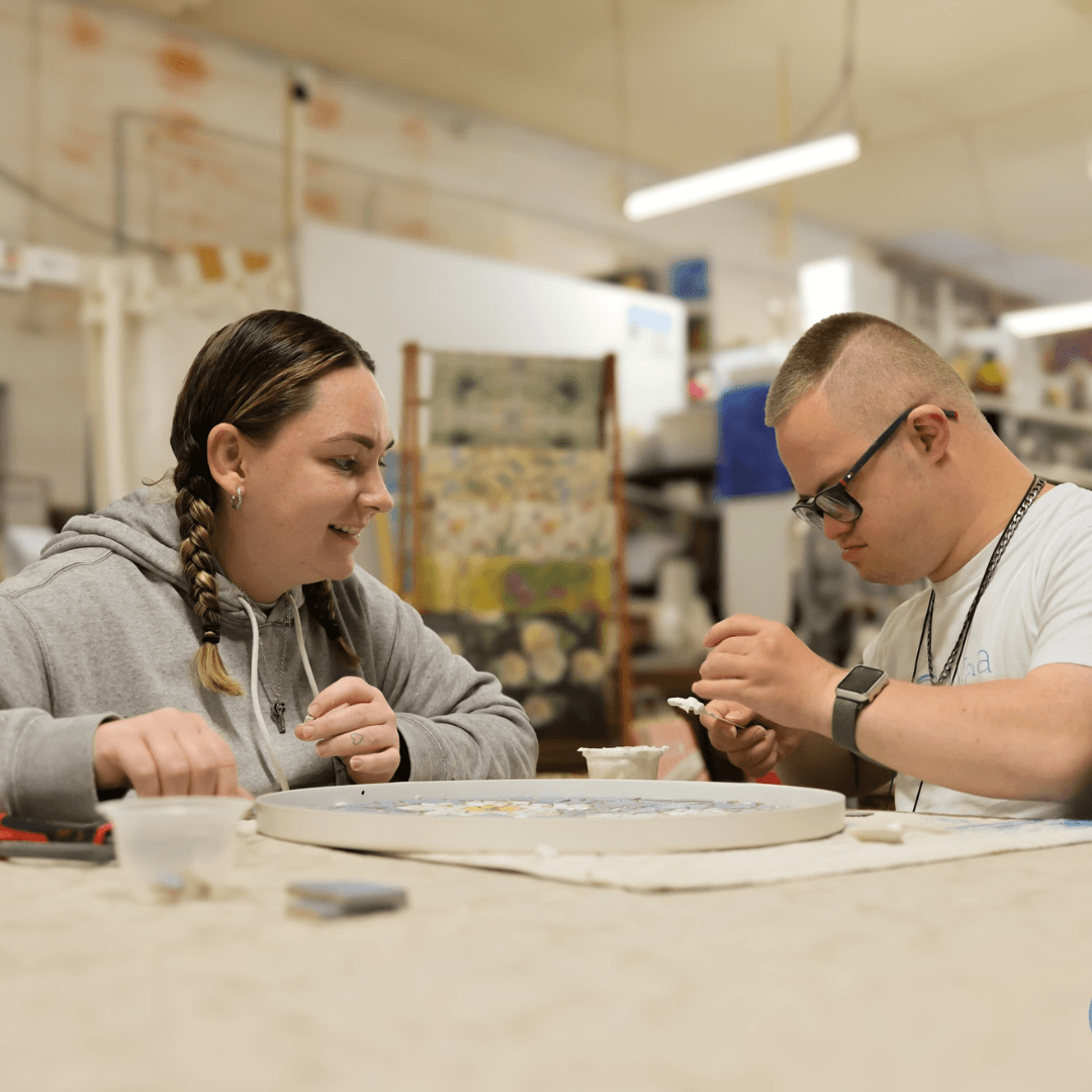A Vana Care support worker helping a client with art